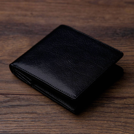 Black leather wallet on a wooden surface