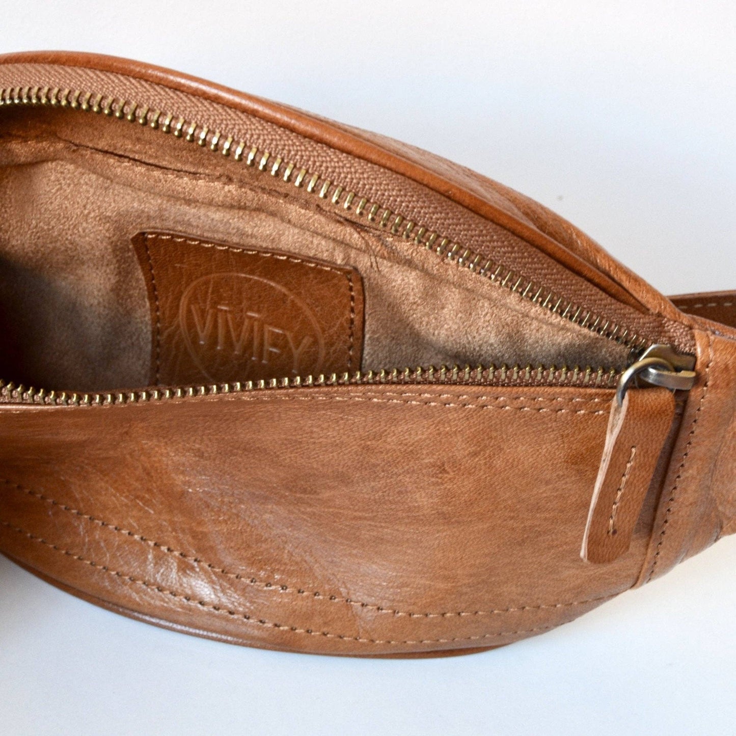 Brown leather waist bag with visible brand logo on a white background