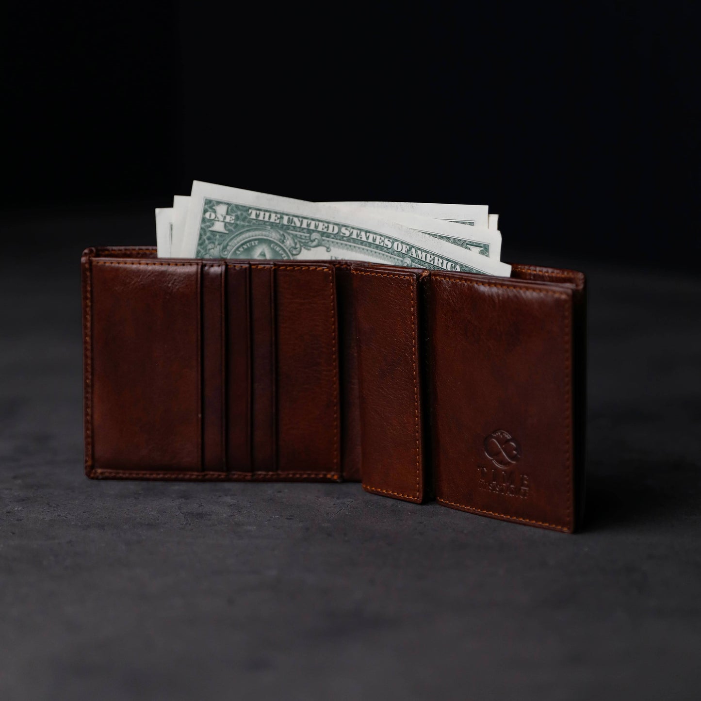 Brown leather wallet with money on a dark background