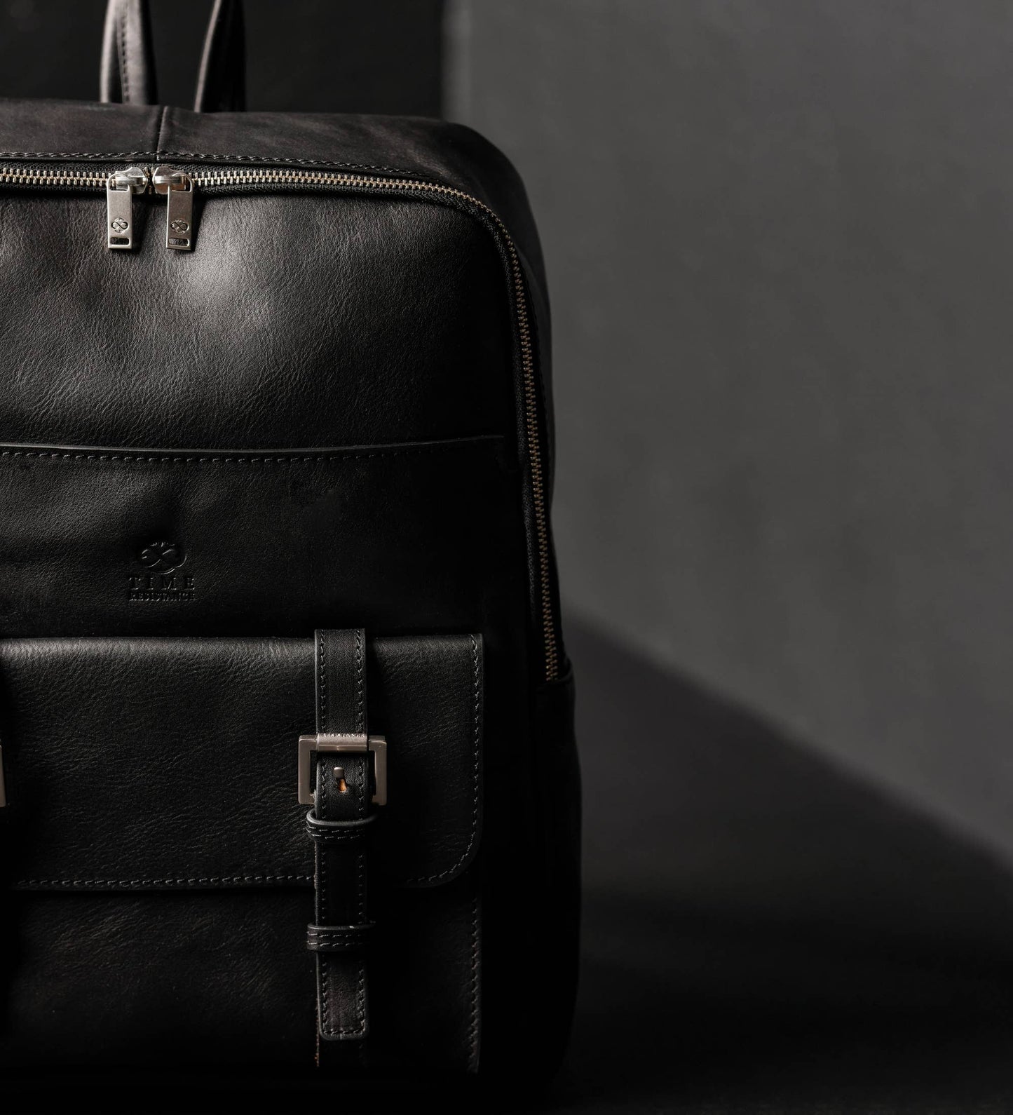 Black leather backpack on a dark background