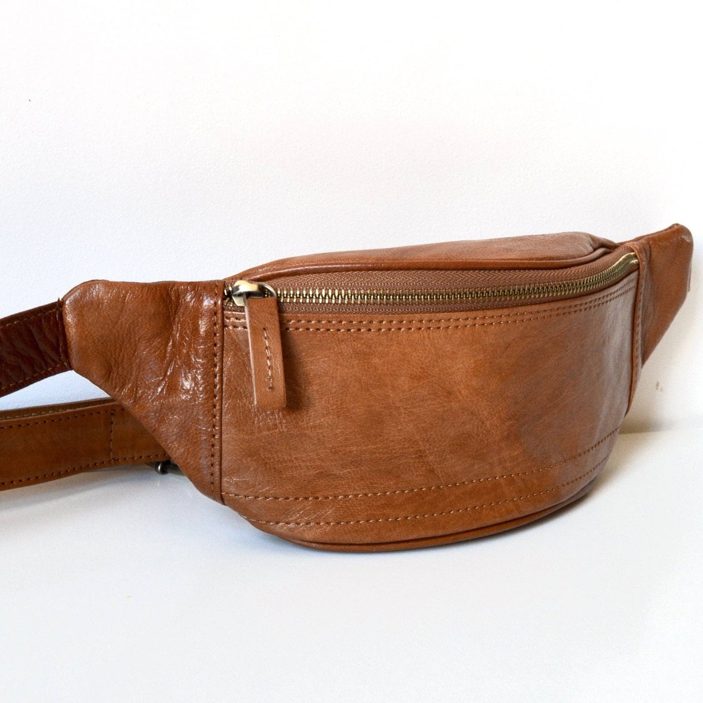 Brown leather fanny pack on a white background