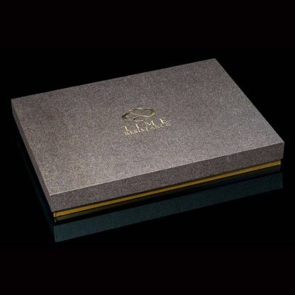Gray textured box with gold accents and a logo on a black background
