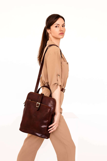 Woman holding a brown leather bag against a white background