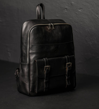 Black leather backpack on a dark background