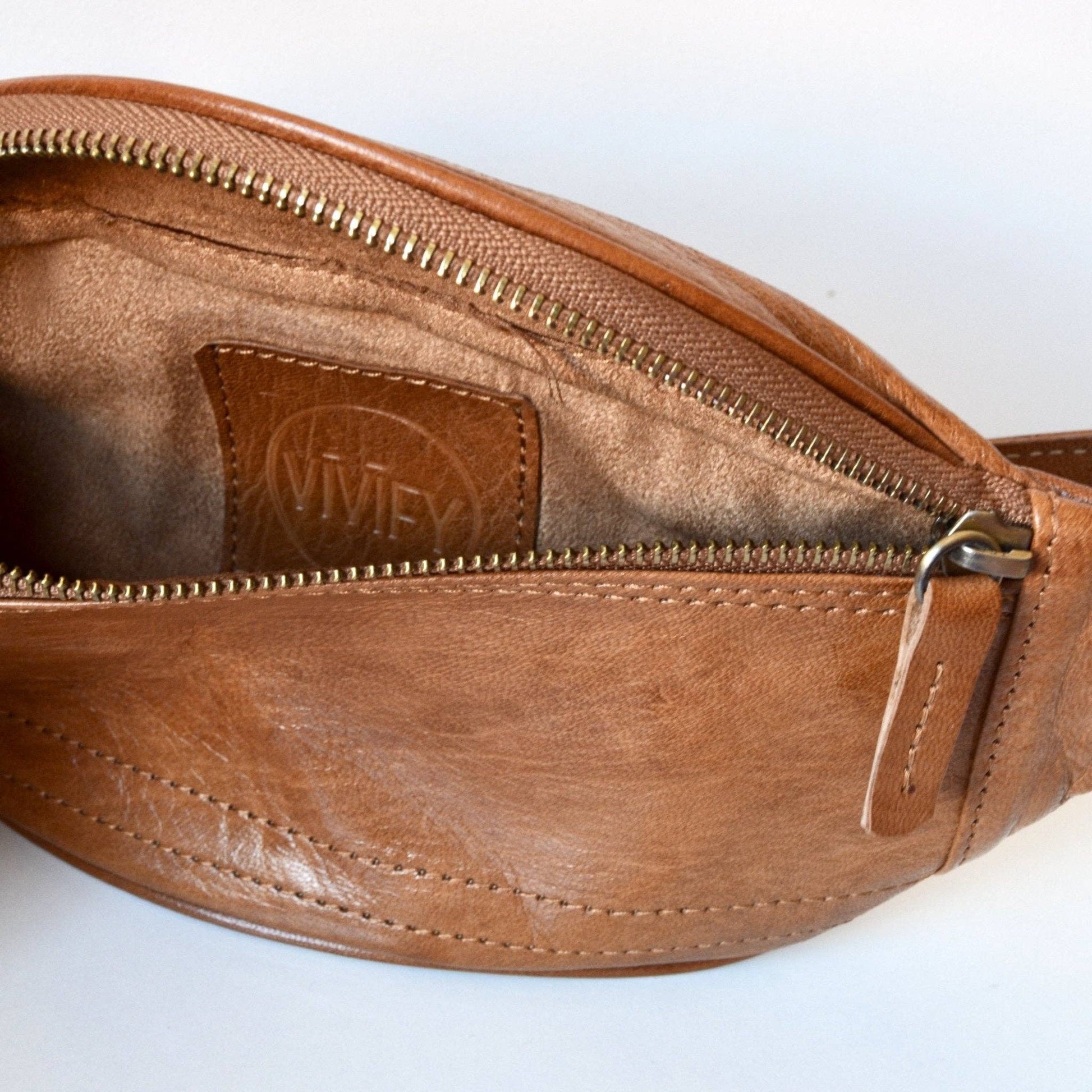 Brown leather waist bag with visible brand logo on a white background
