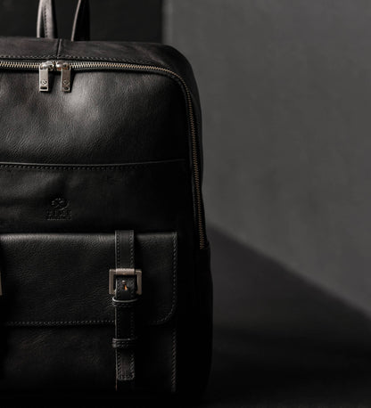 Black leather backpack on a dark background